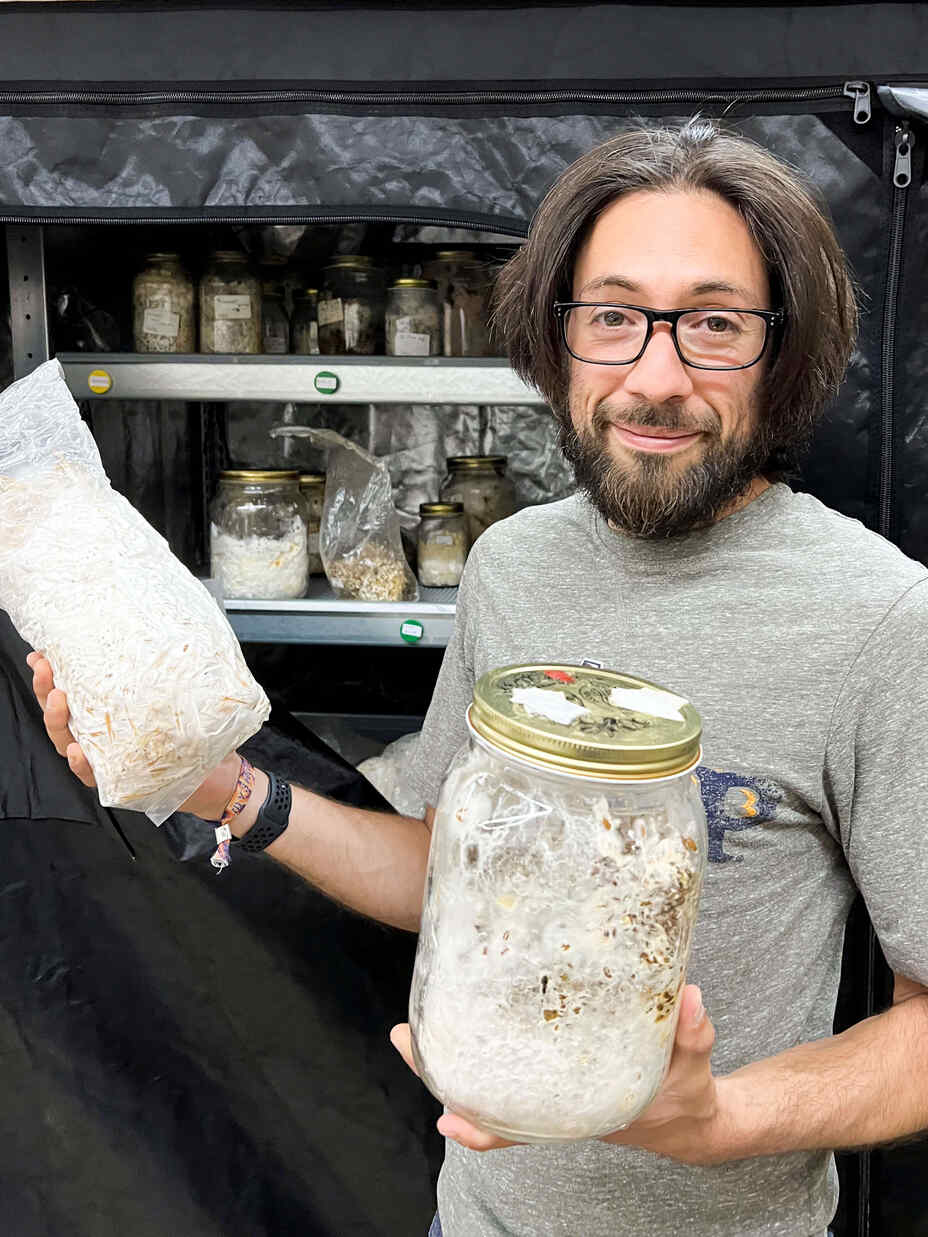 Ruben hält Gläser mit Pilzmaterial in der Hand