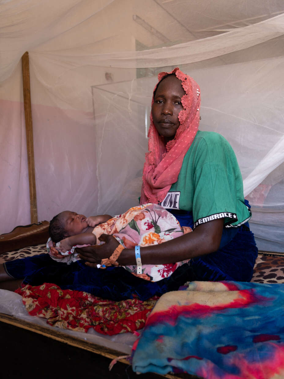 En mamma i Sudan håller sitt barn.