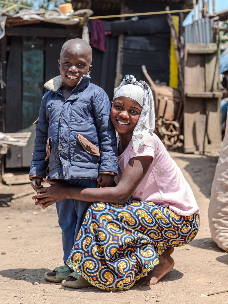 Gentille with one of her foster siblings outside their home. 