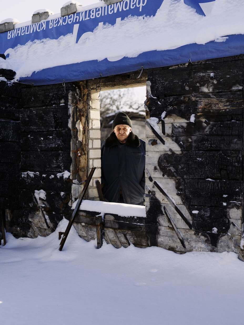 빅토르가 폭격으로 폐허가 된 집에서 카메라를 바라보고 있습니다.