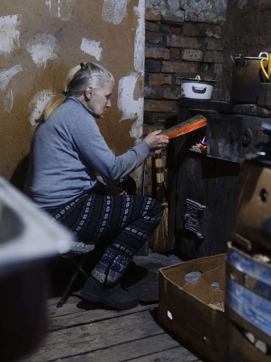 나탈리아가 난로에 불을 붙이고 있습니다.