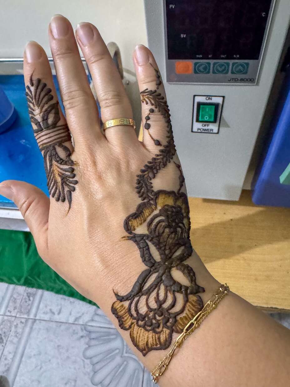Basma shows the henna design on her hand