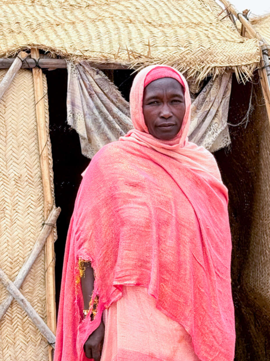 Hawa (45), poses for a photograph outside her shelter.