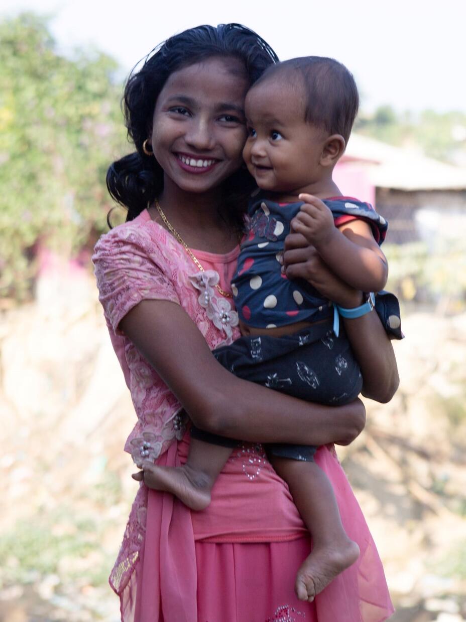 Nur Kiyas holding an infant sibling