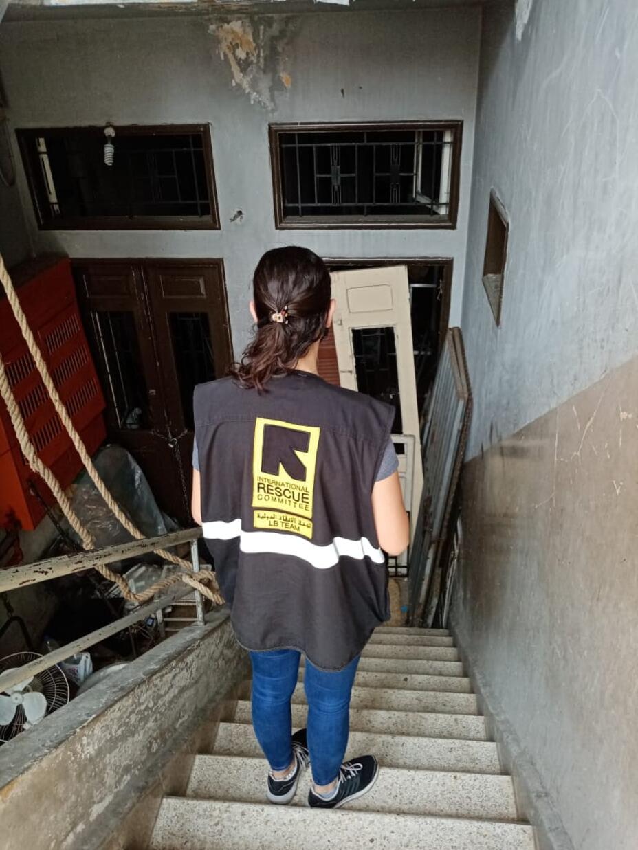 A woman wearing an IRC vest standing on staircase