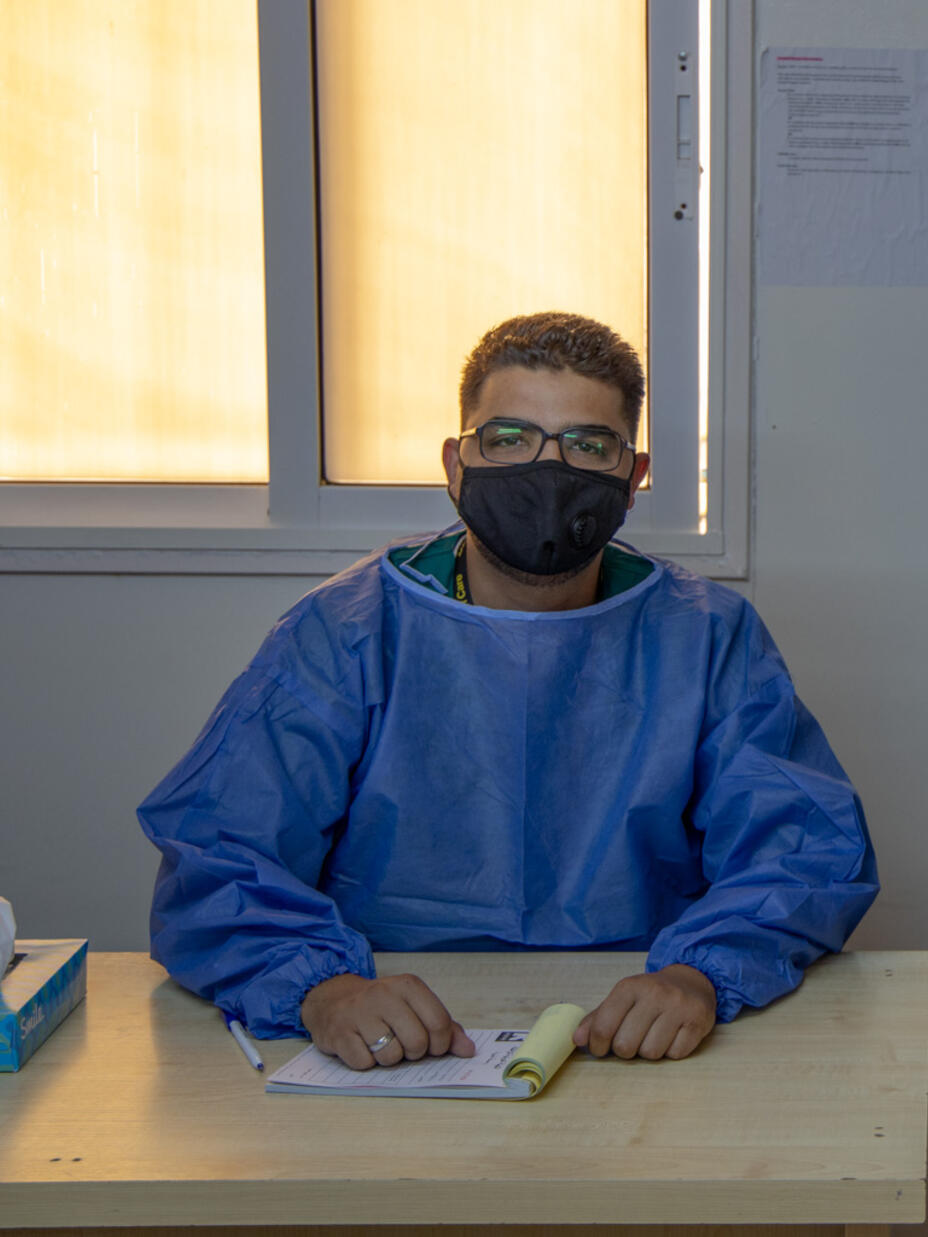 Dr Abedalhaleem Albalasmeh sits at his desk wearing PPE