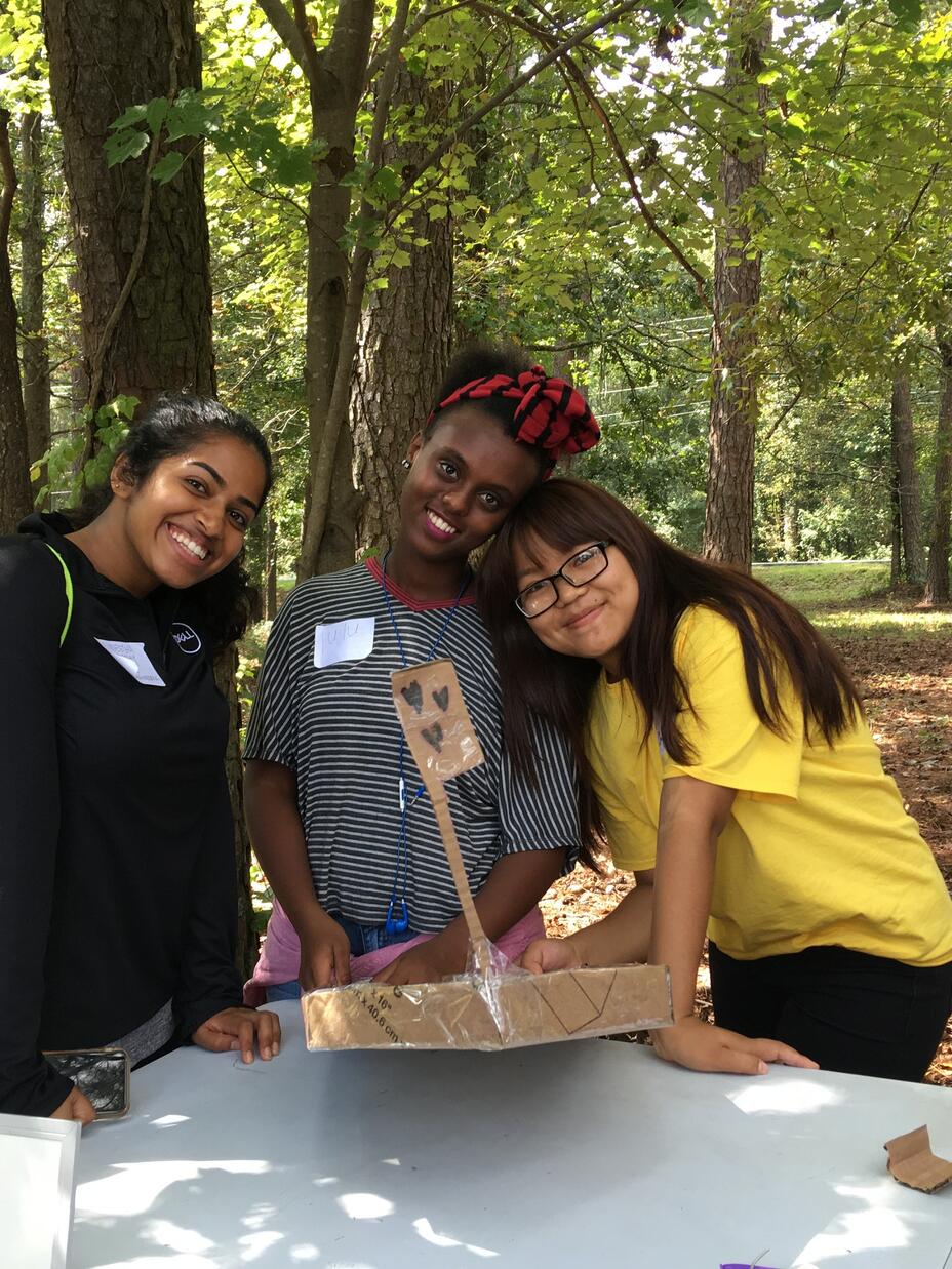 A Georgia Tech volunteer and Youth Futures students with their finished boat. 