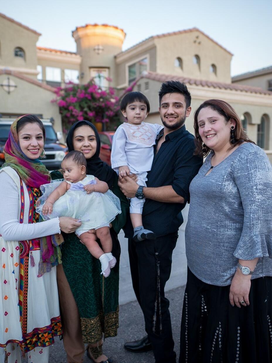 Resettled family stands in front of their home in the United States