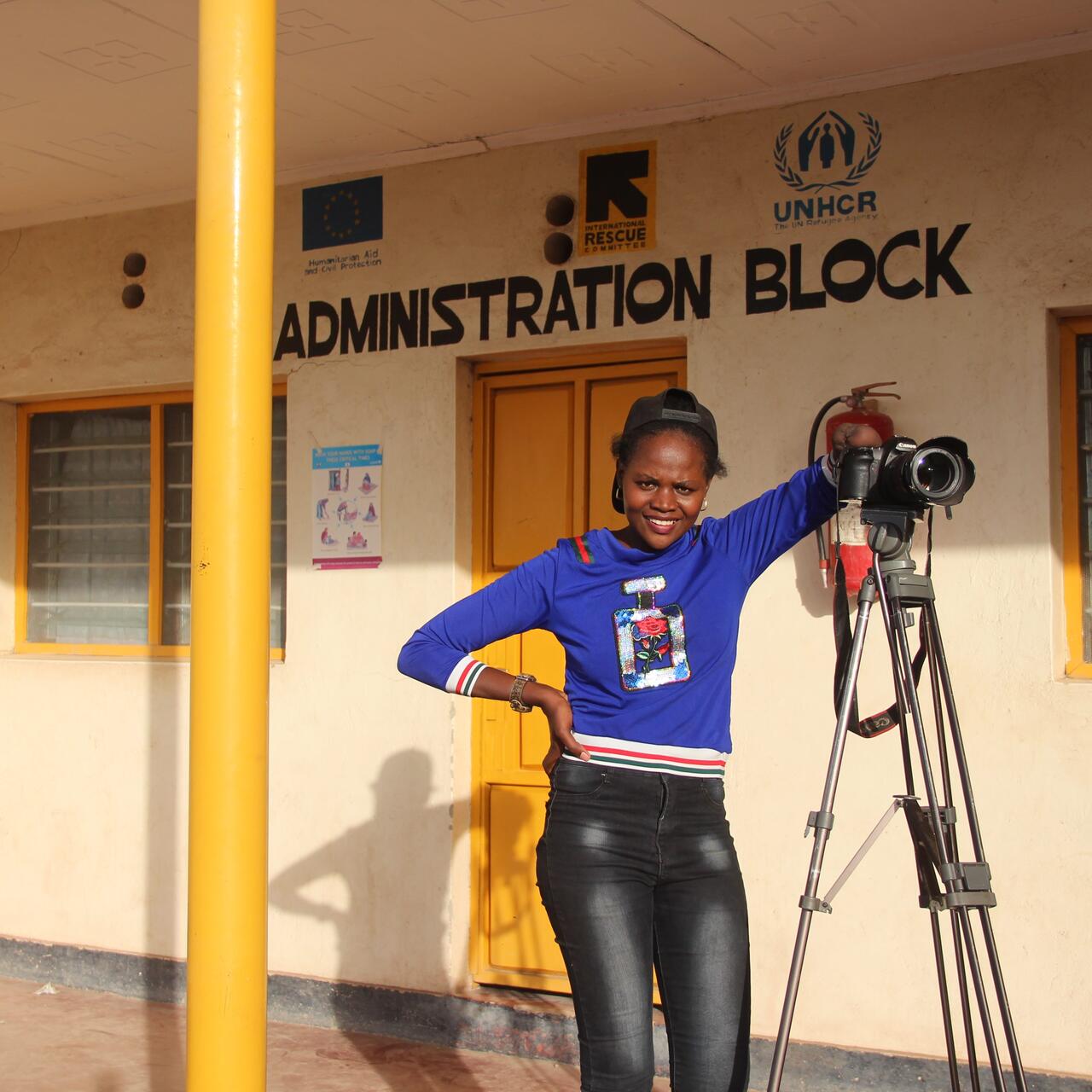 patience posing with her camera in front of an office