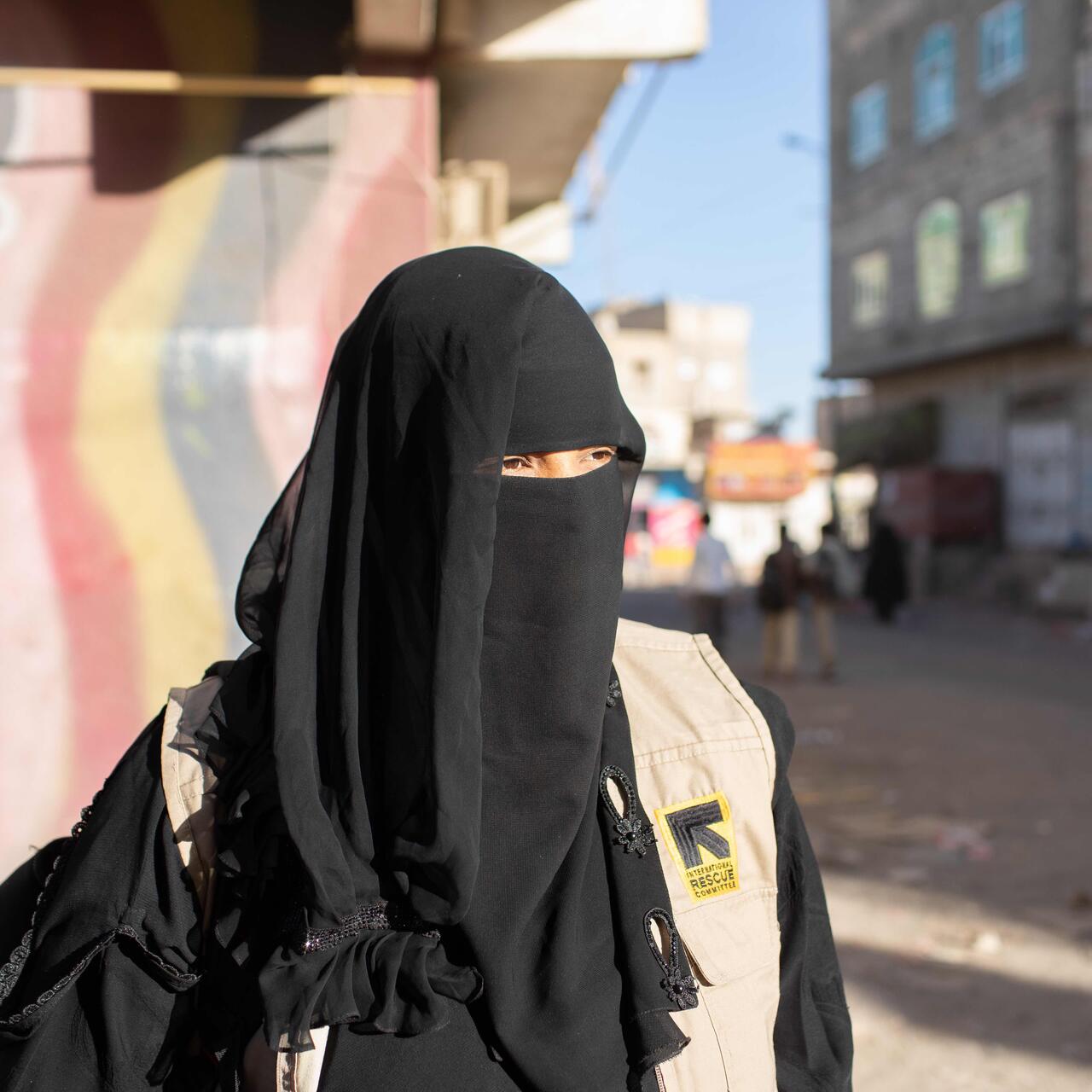 Tahani is fully veiled and is walking in a street