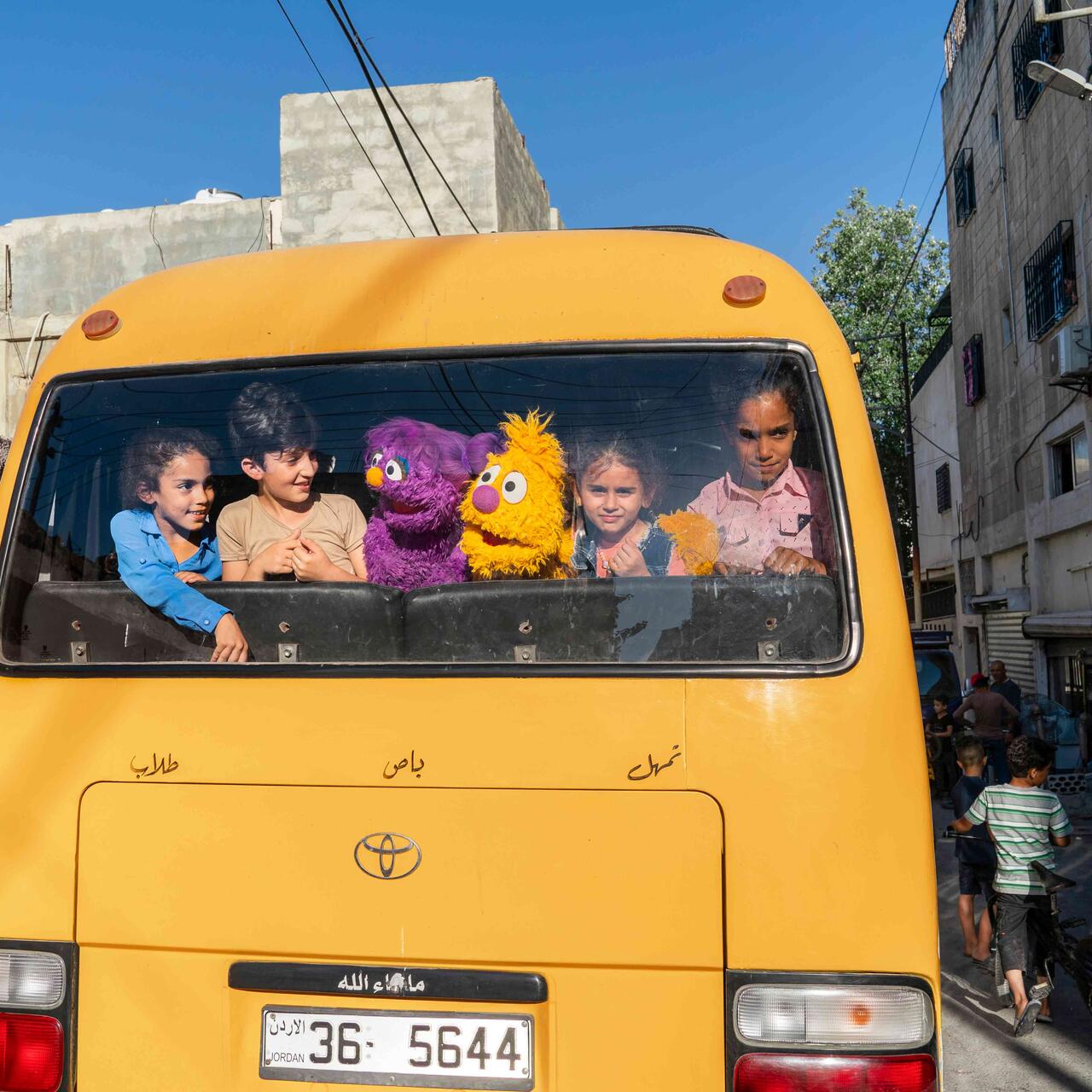 Die neuen Sesamstraße Puppen Jad und Basma nehmen den Bus mit Flüchtlingskinder in Amman