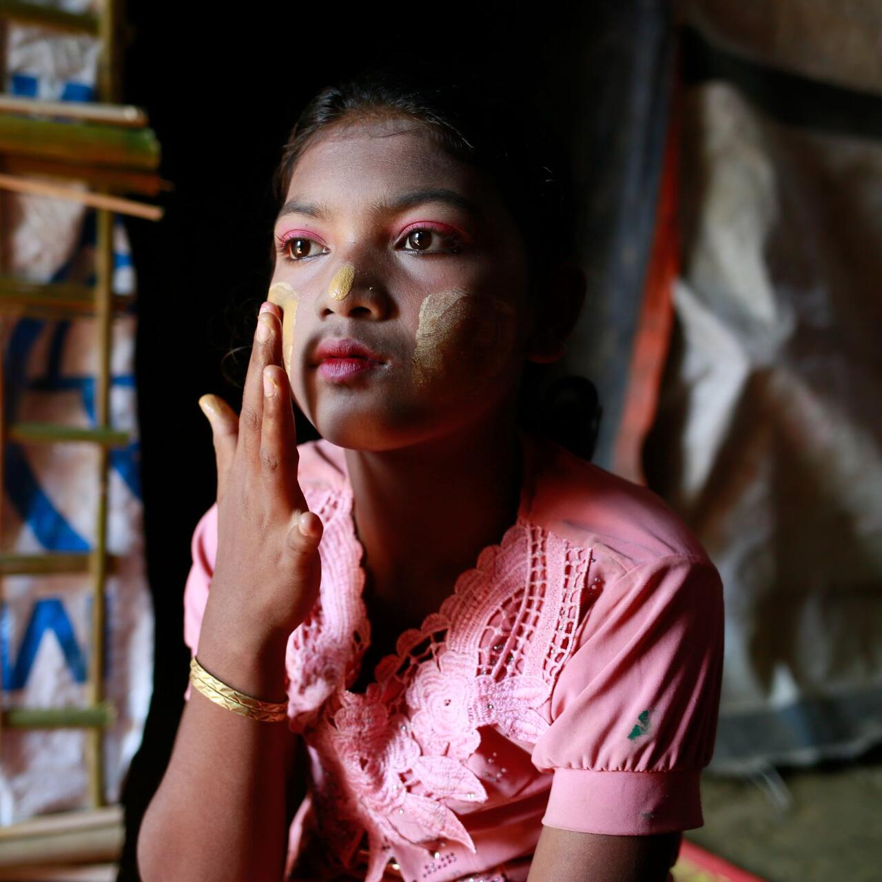 Hasina applying traditional make-up to her face