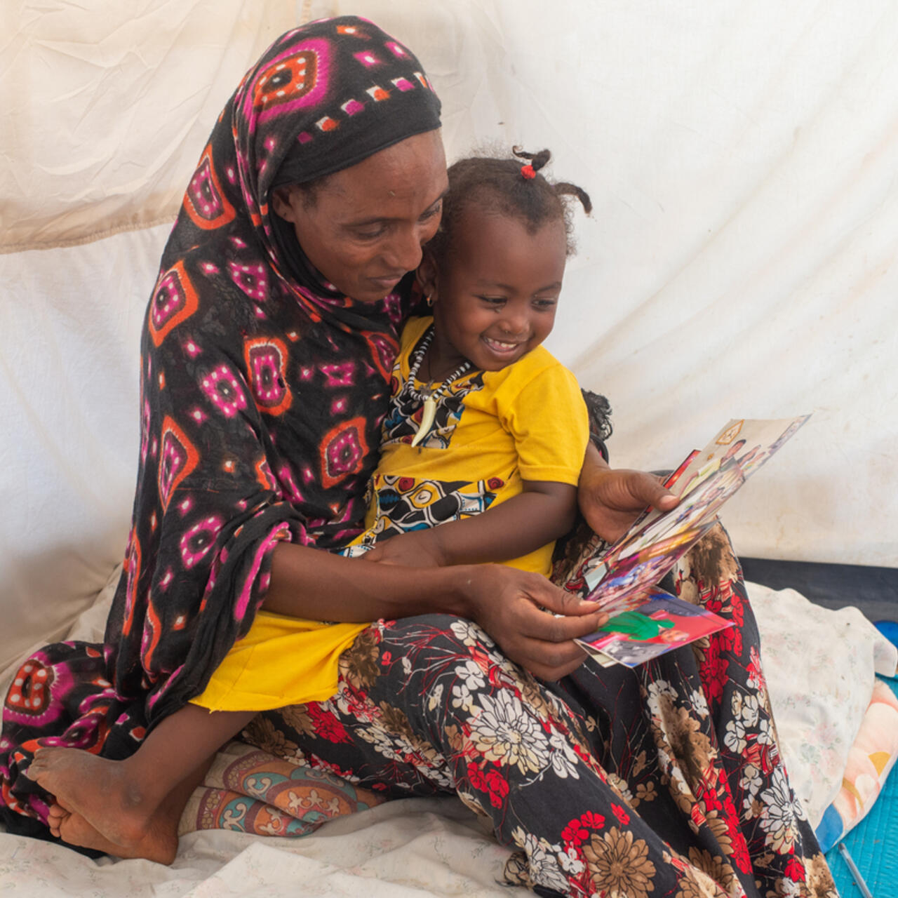 Mulu and her daughter looking at photos Mulu brought from Ethiopia