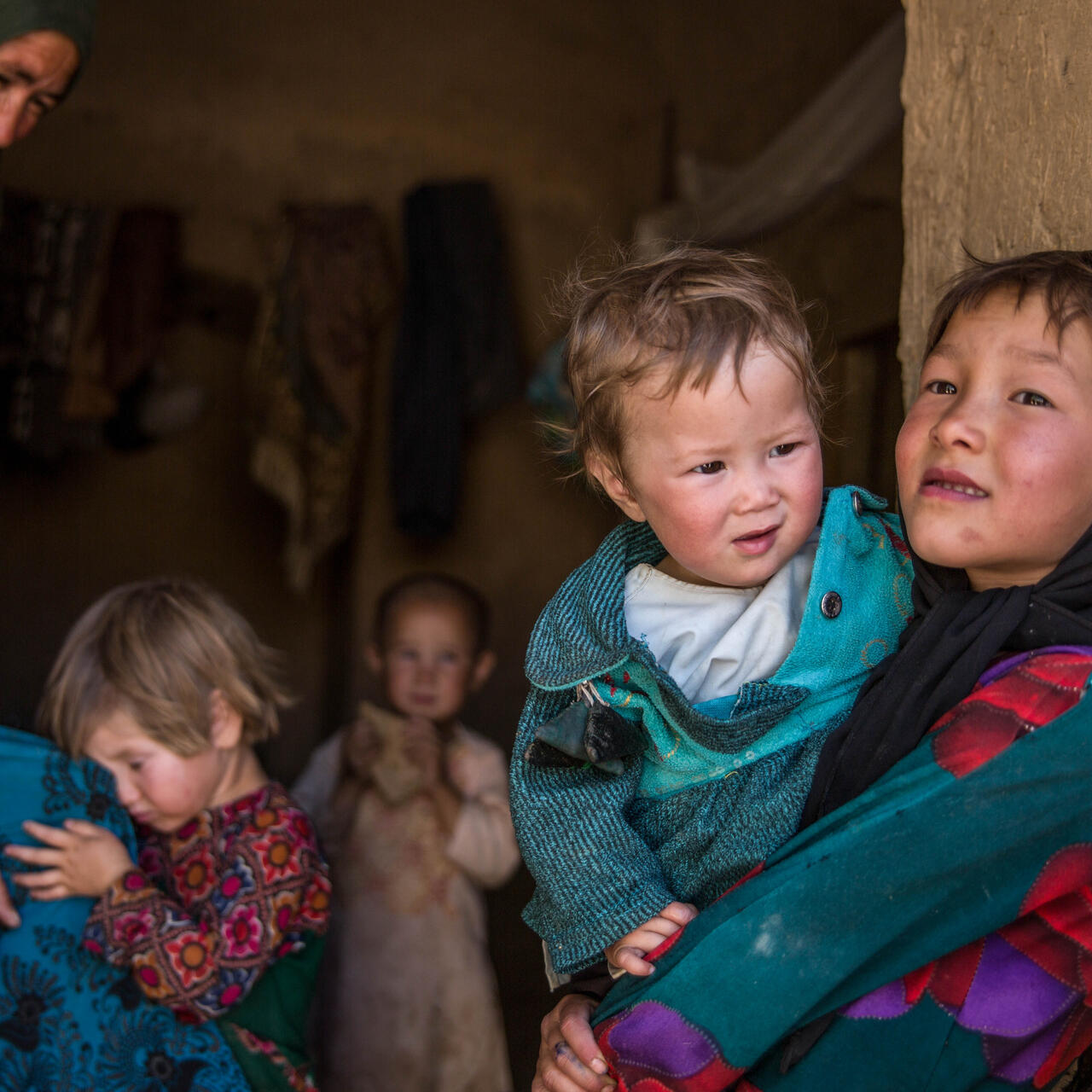 Ett barn håller sitt syskon i armarna i Afghanistan