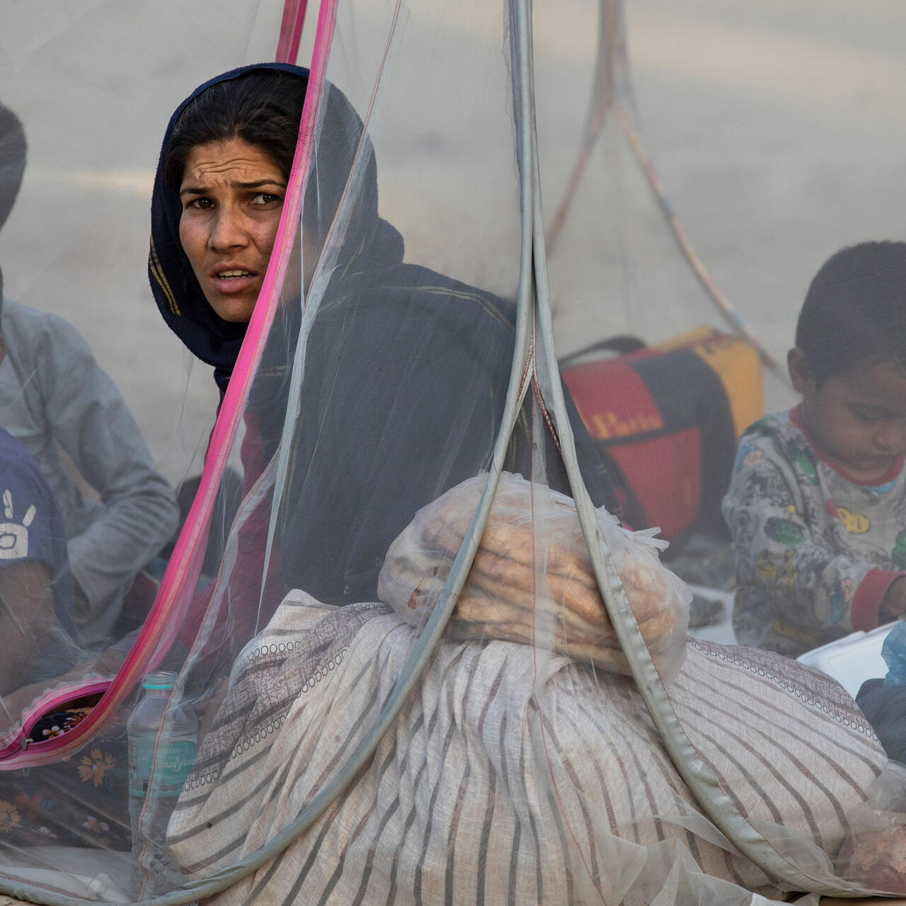 Familj som är på flykt i Afghanistan sitter i sitt tält