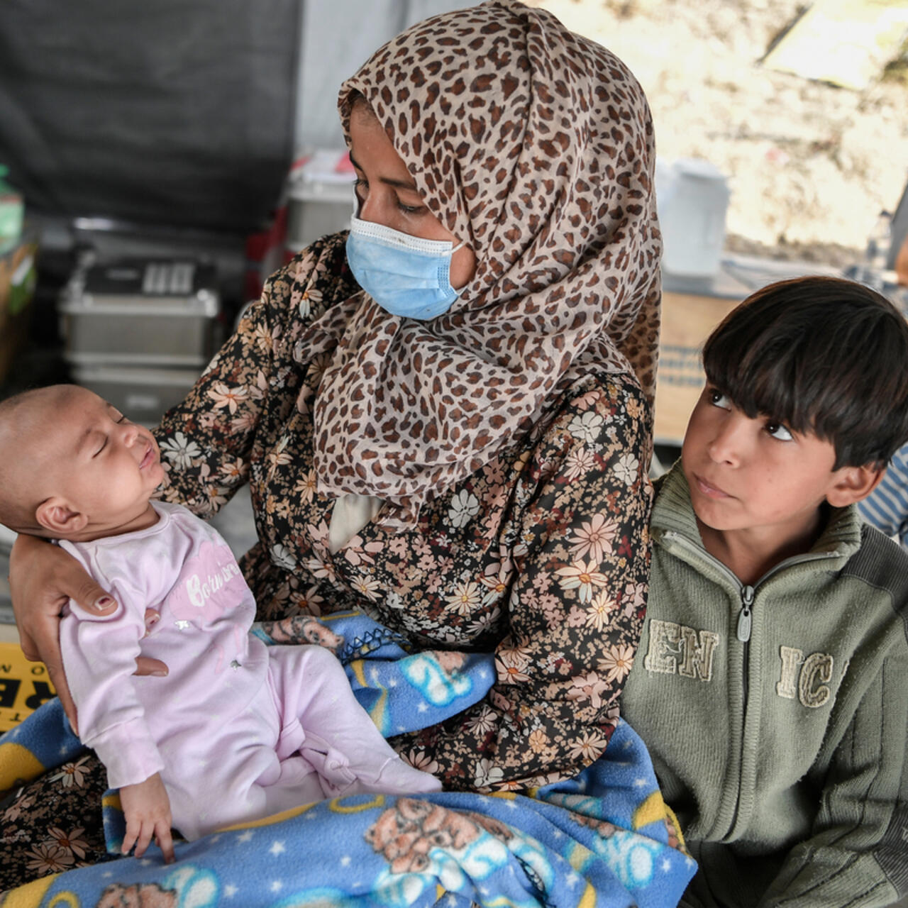 Syrian mother holding her sick baby daughter