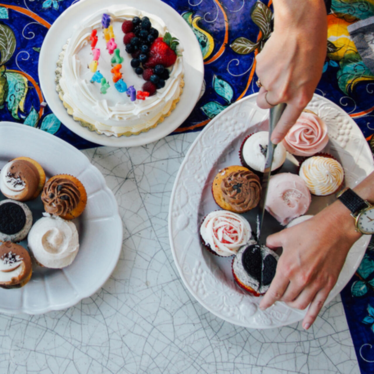 A person cuts up cakes at charity birthday party