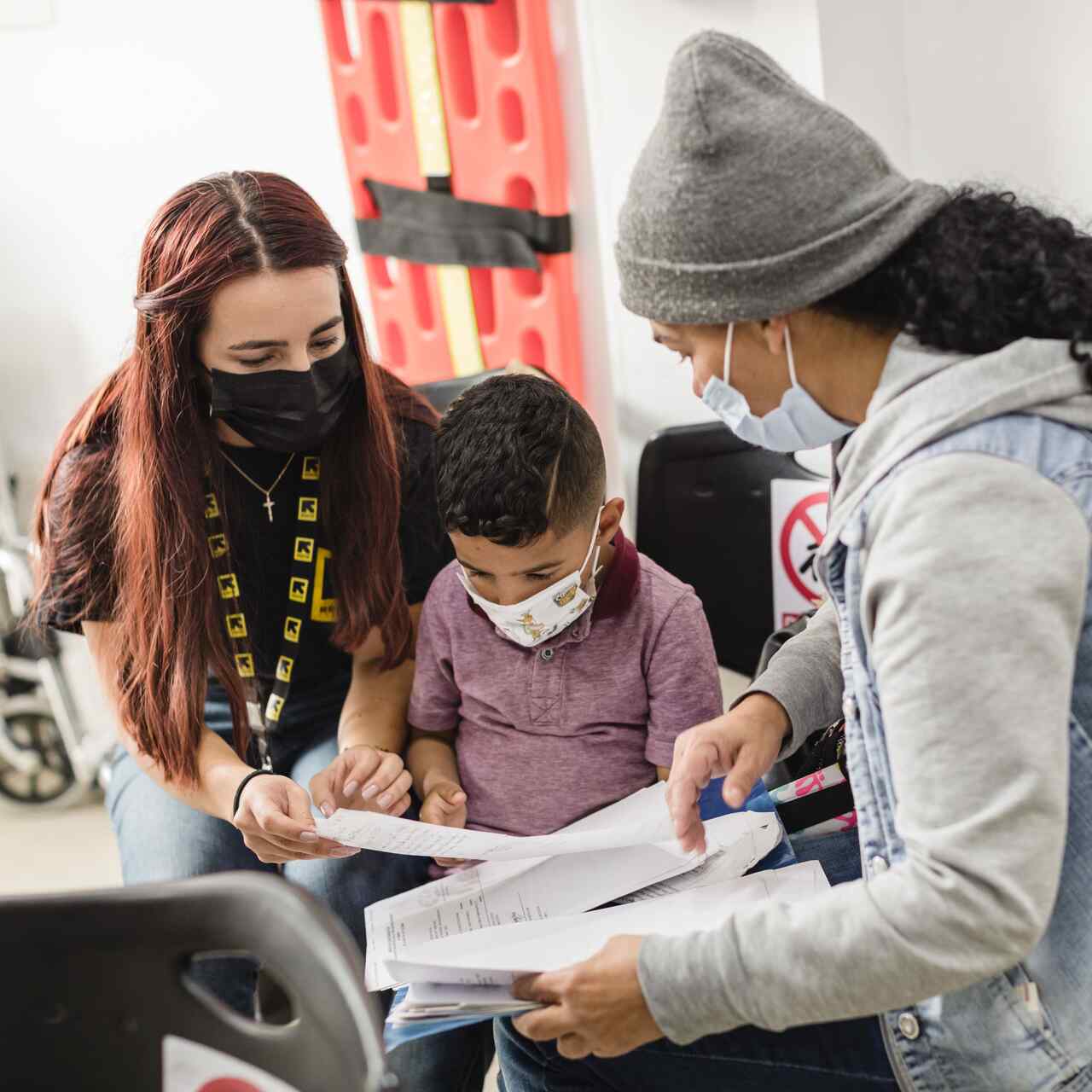 IRC member reading documents to a mother and son.