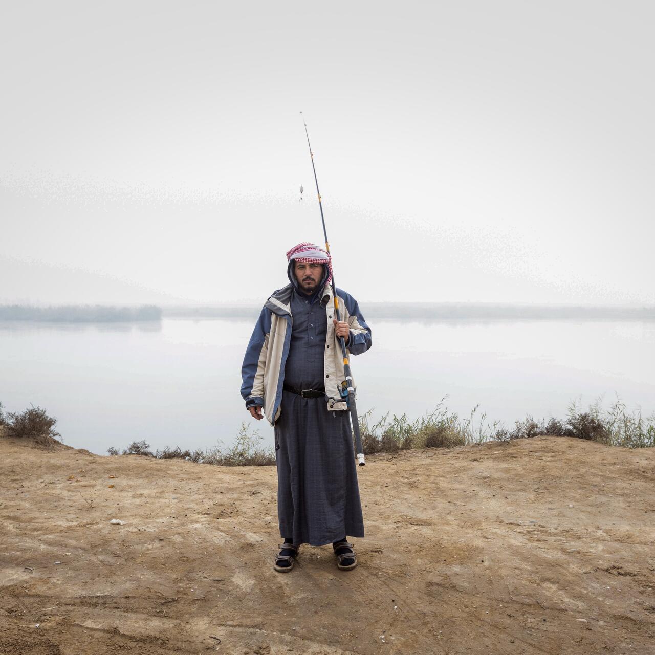 Salem*, a fisherman who recently recovered from cholera, stands by the Euphrates River. He had received full health care from the International Rescue Committee (IRC), besides awareness and education sessions for him and his family.