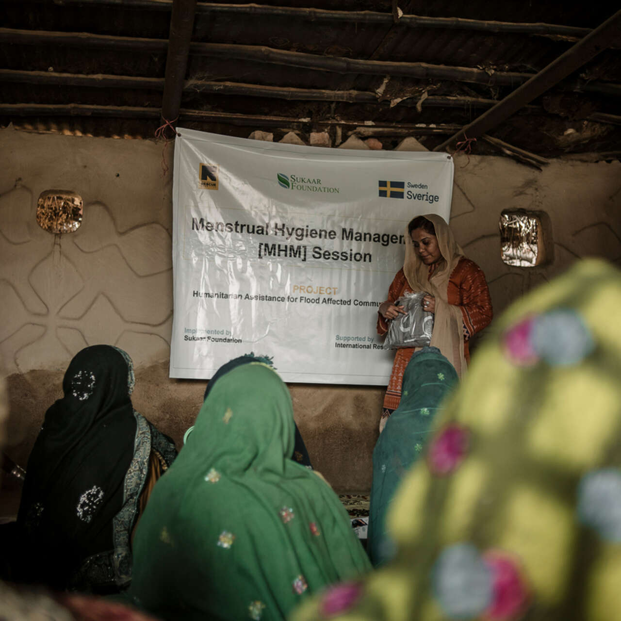 En kvinna föreläser om hygien för en grupp andra kvinnor utanför Sanghur, Pakistan.
