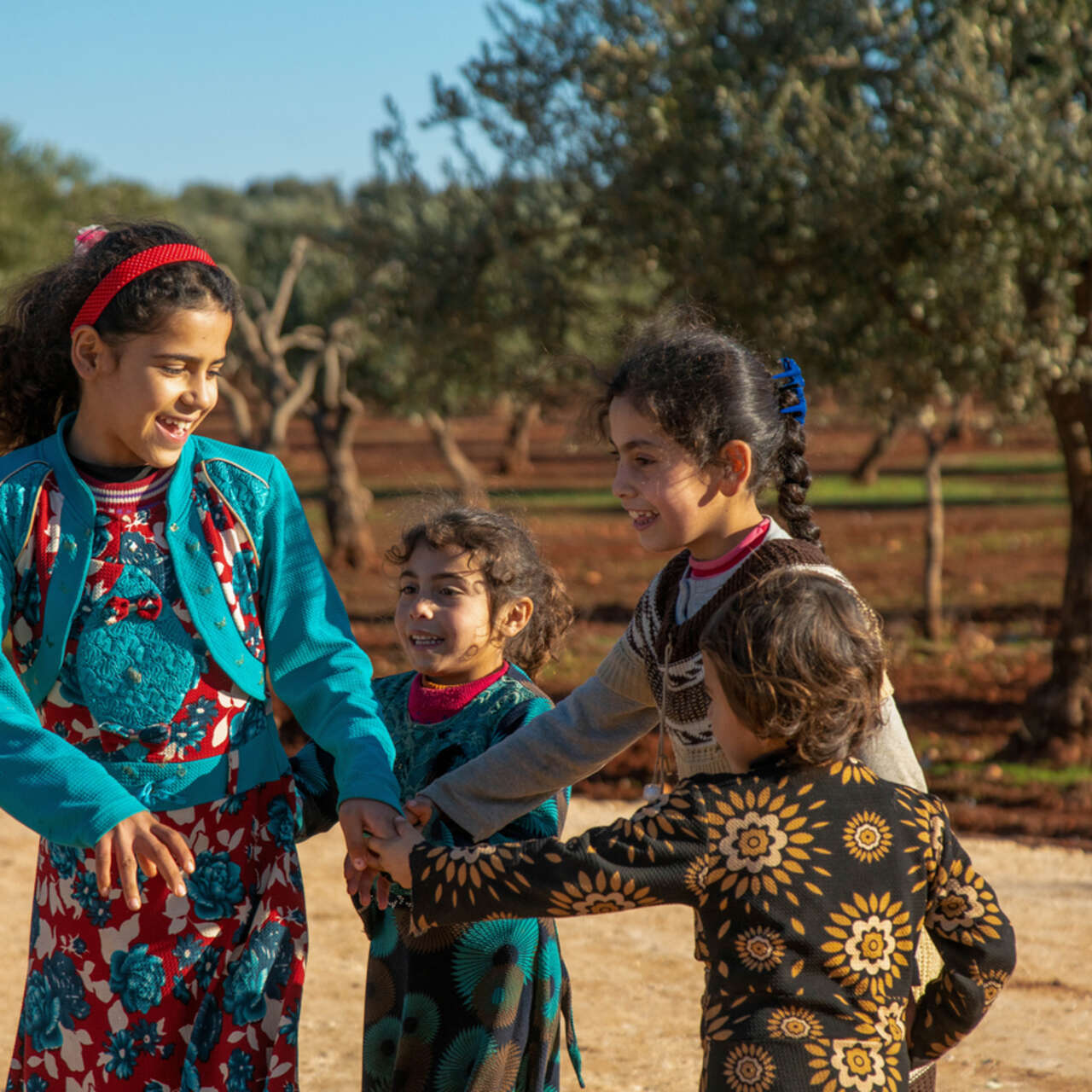 Fyra syskon leker i ett flyktingläger i nordvästra Syrien. 