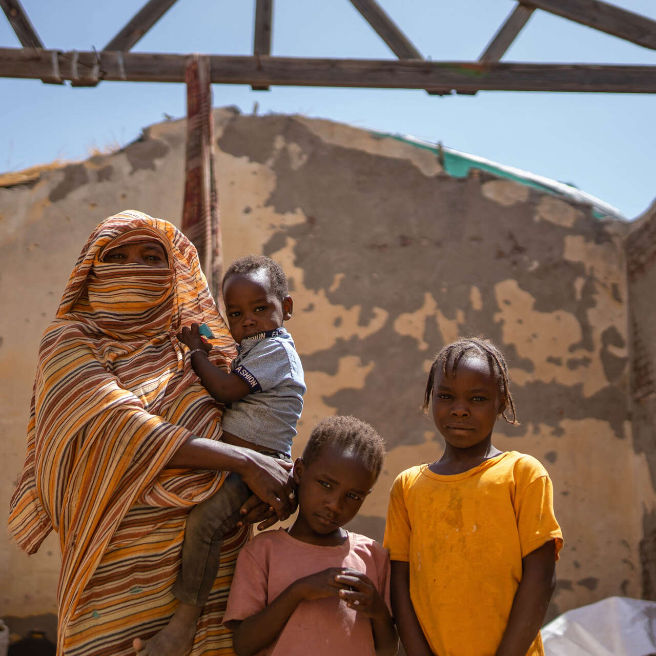 Eine sudanesische Familie posiert für ein Foto in den Ruinen eines durch den Konflikt zerstörten Gebäudes.