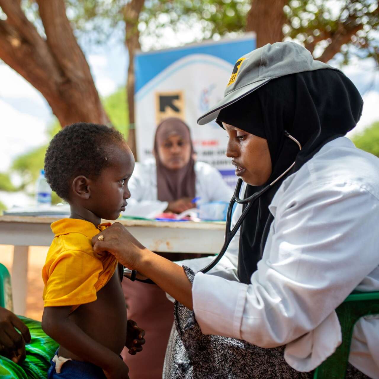 A person with a stethoscope examining a child