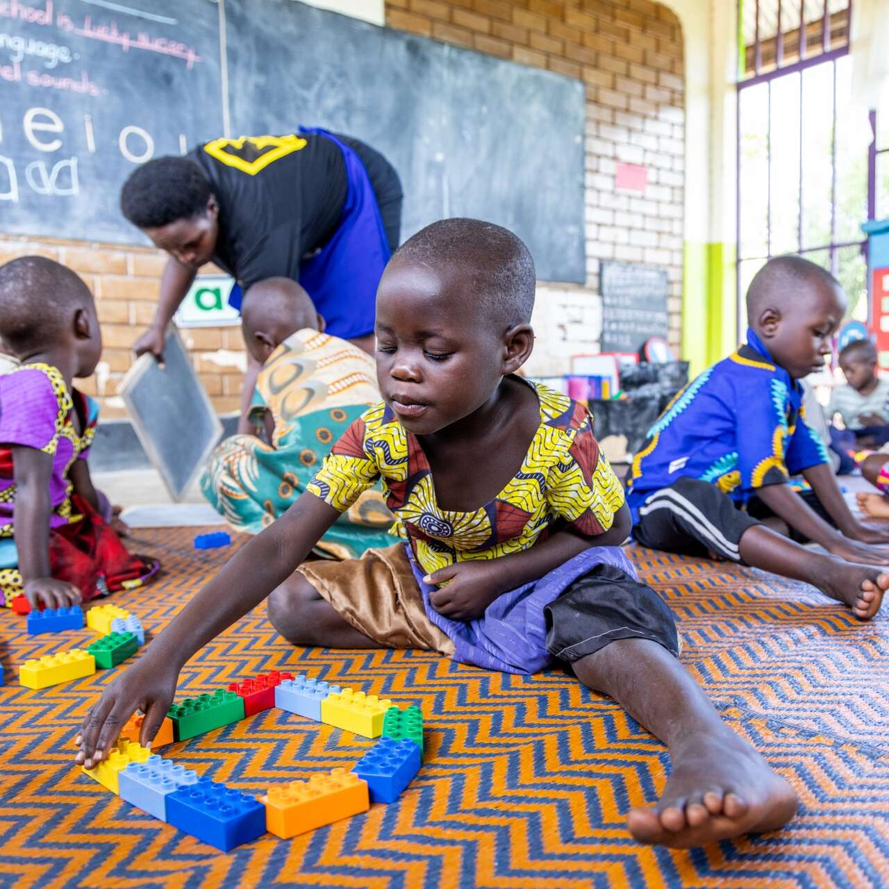 Children play at a LEGO Foundation exercise in Uganda.