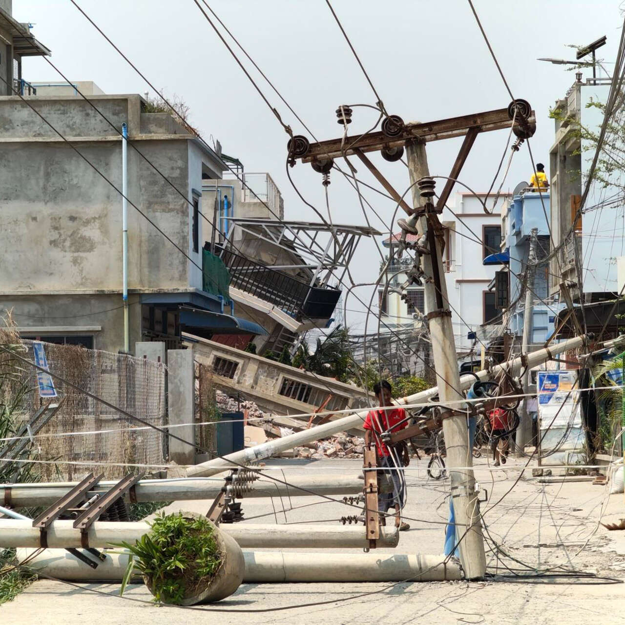 A man examines a downed power line caused by the earthquake in Myanmar.