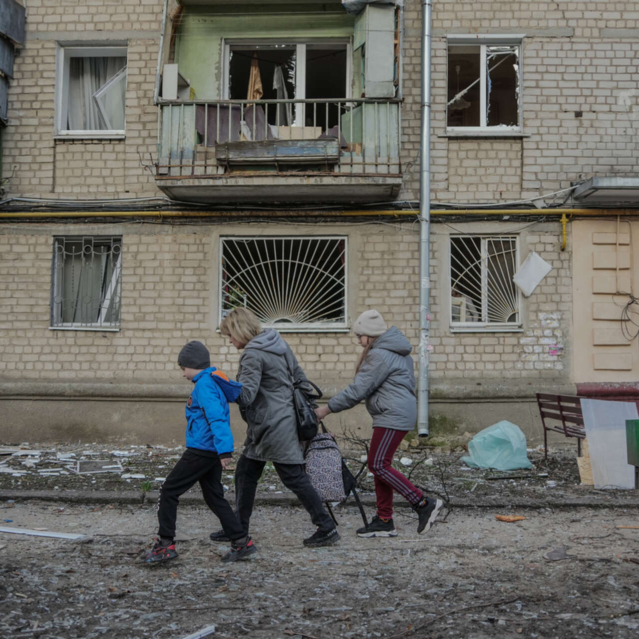 En mamma och hennes barn evakuerar från ett höghus i Charkiv, Ukraina, efter en rysk flygbombning.