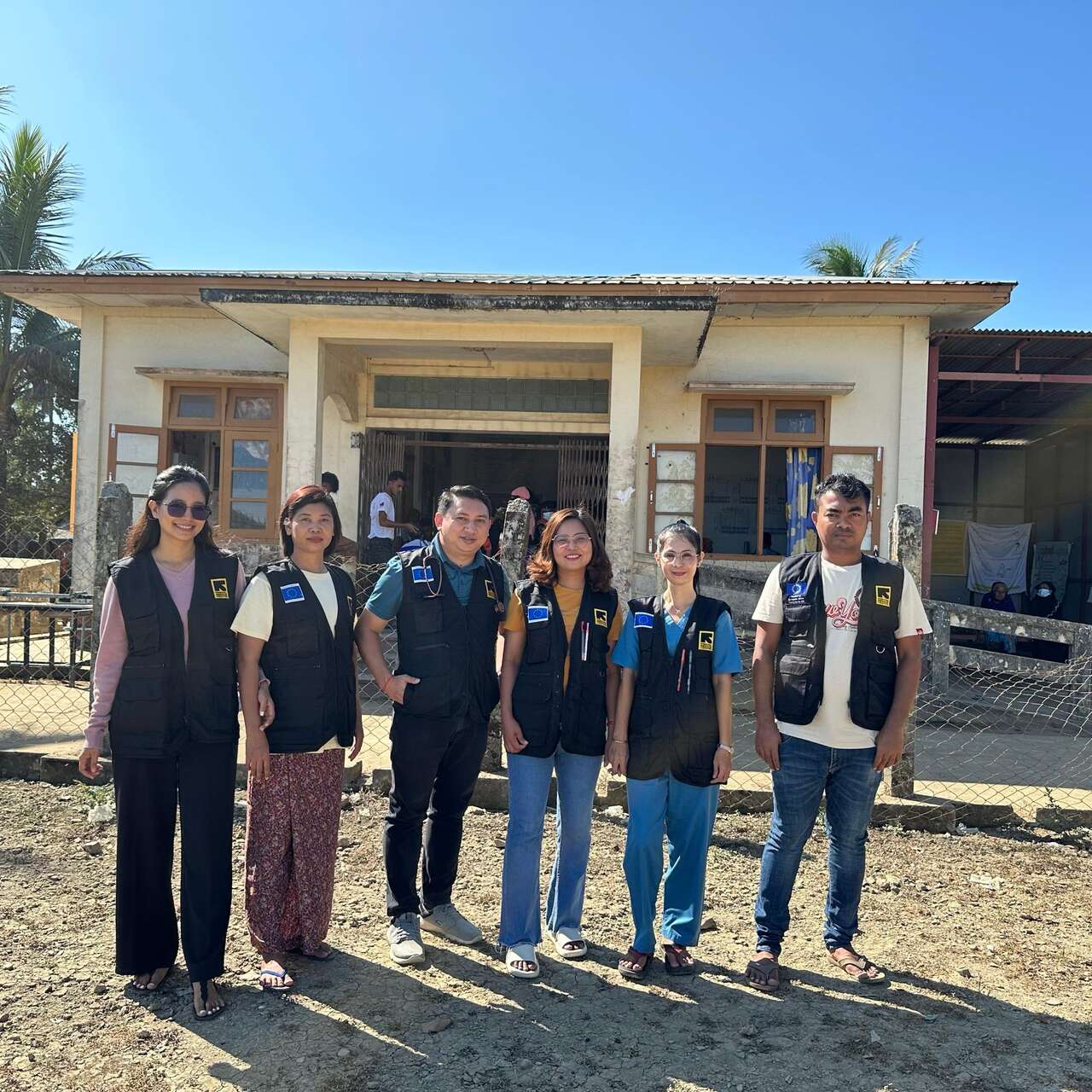 A group of pPeople working at a Mobile Clinic in Myanmar with IRC/EU blue vests.