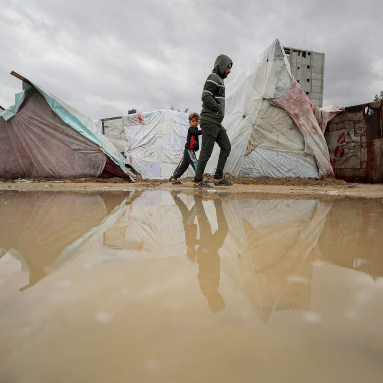 A reflection of Palestinians living in makeshift tents, struggling with harsh weather conditions amid Israeli attacks in Deir al-Balah, Gaza.