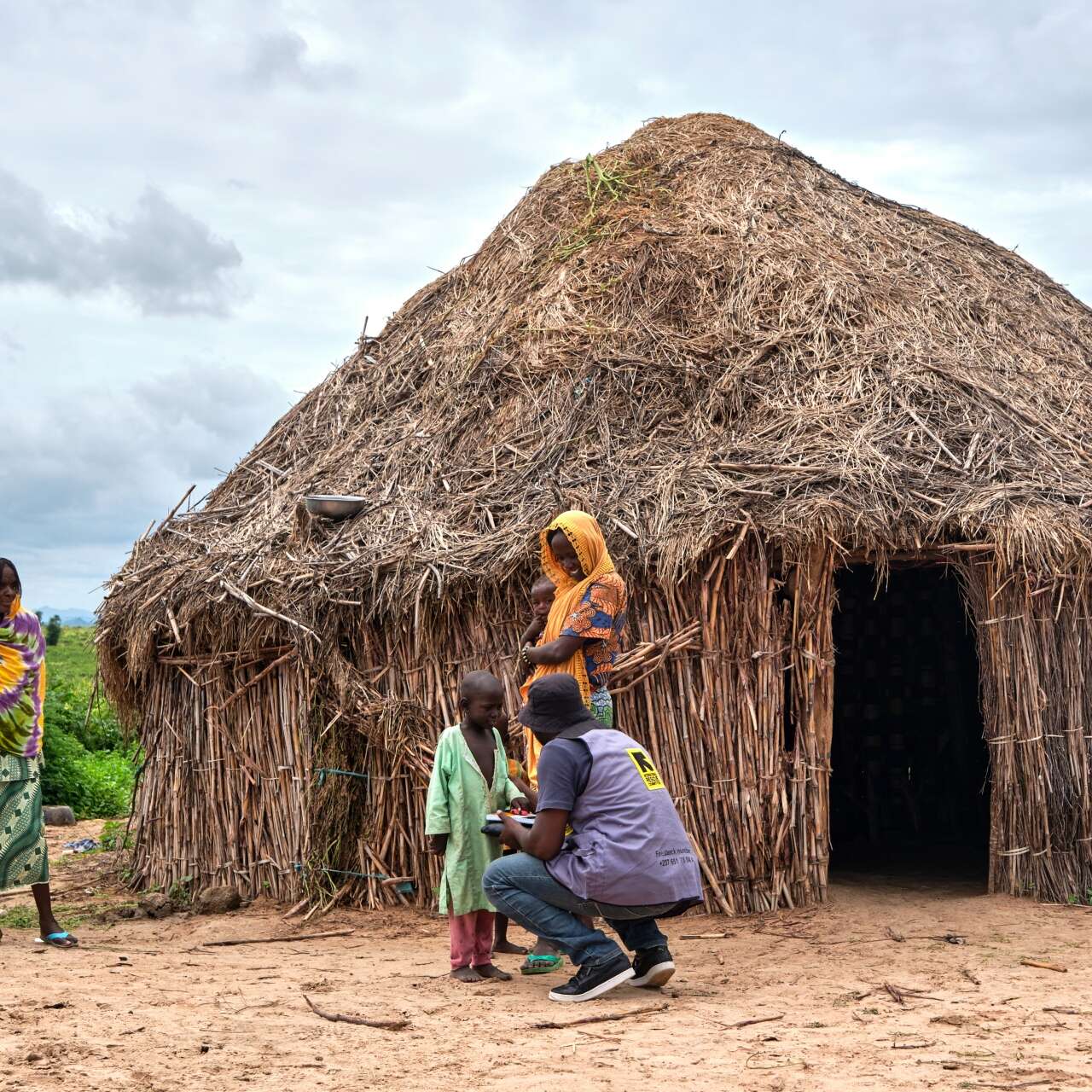 An IRC health worker treats a child outside of their home in northern Cameroon.