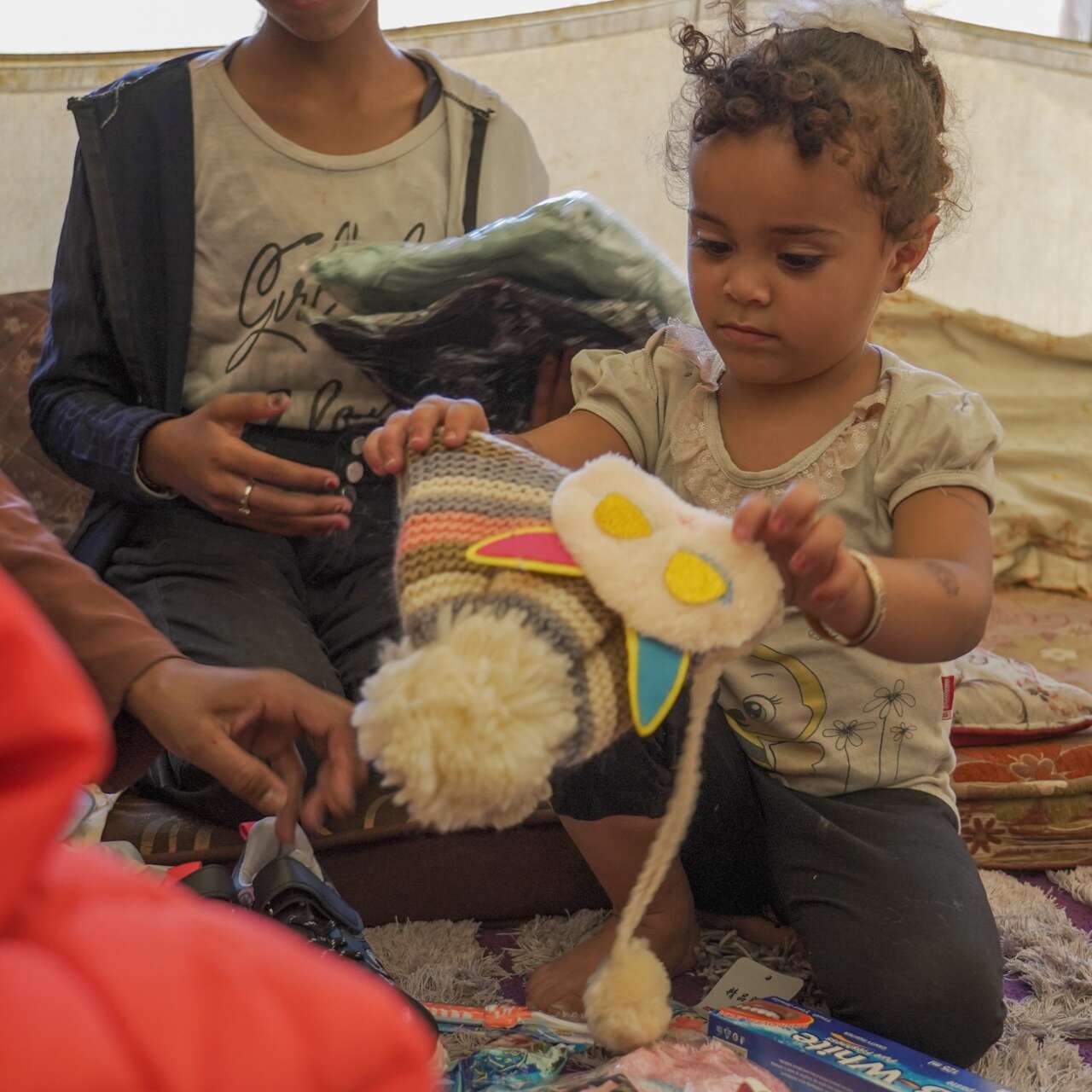 A young girl receives a new winter hat from the IRC in Gaza.