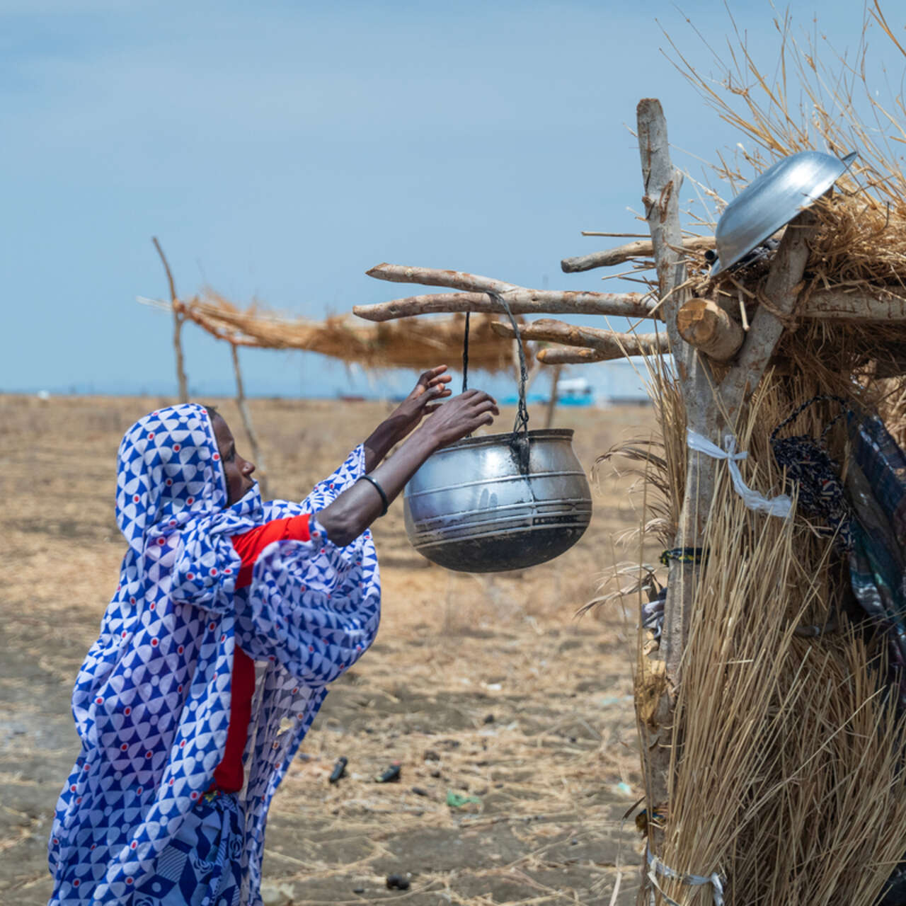 En kvinna sträcker sig efter en gryta för att förbereda mat. 
