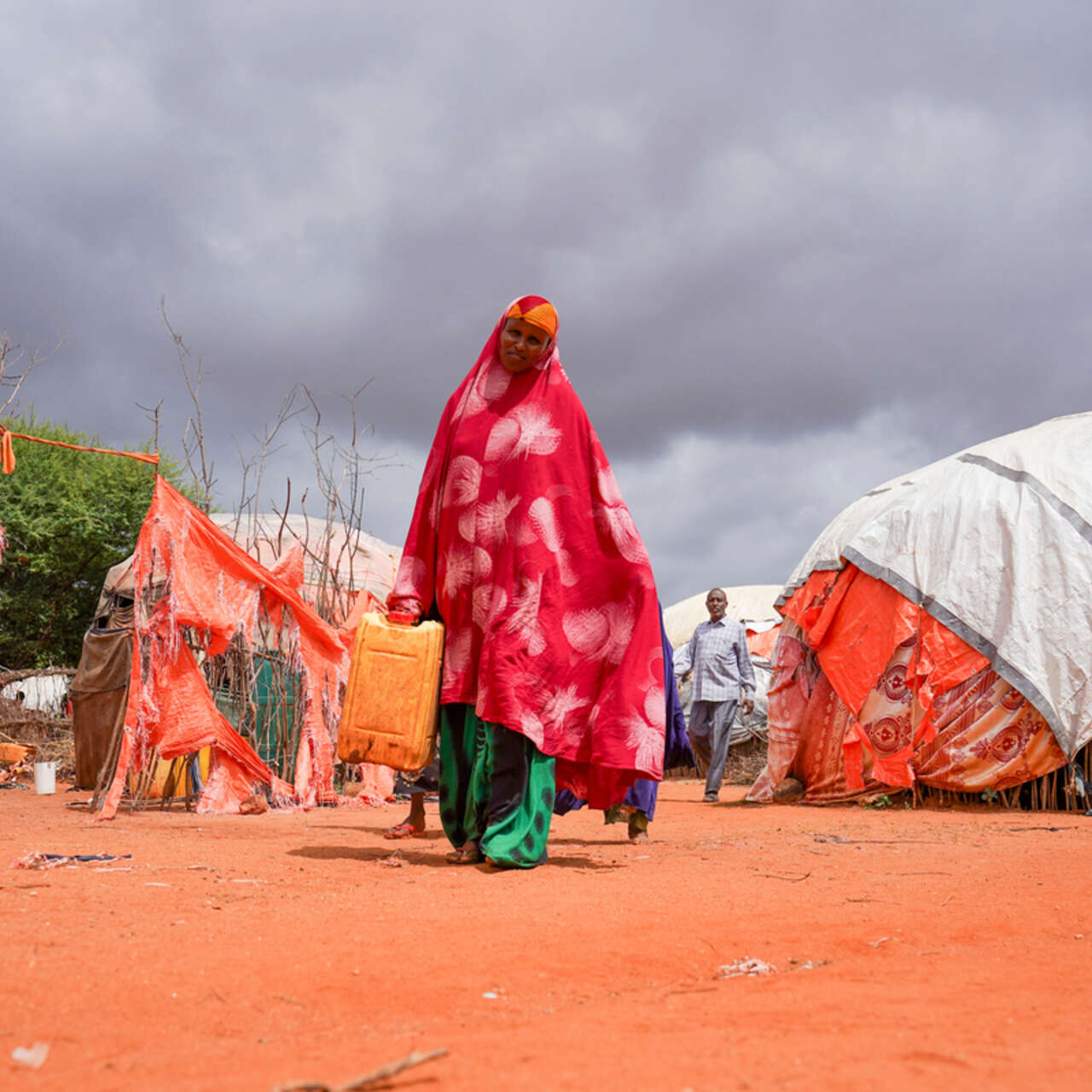 En kvinna går genom ett flyktingläger. 