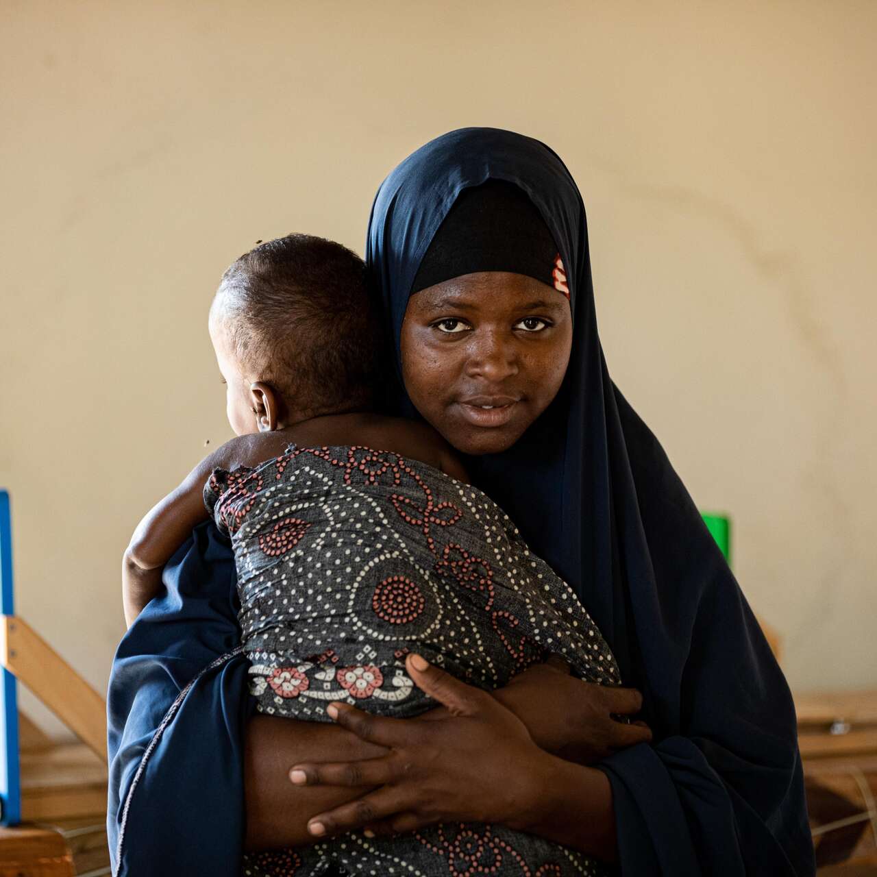 Shukri a Sudanese refugee in Kenya is holding her child 