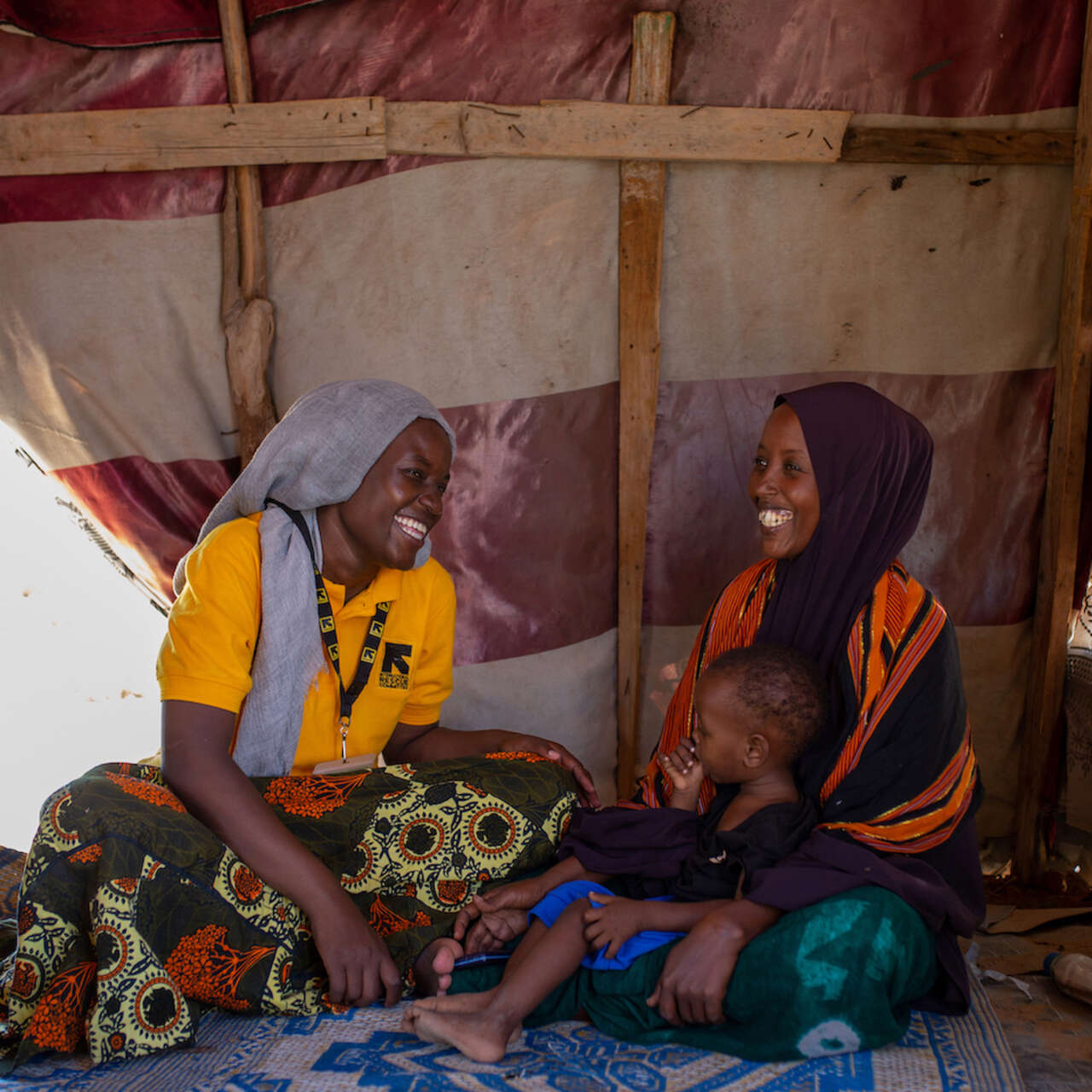 국제구조위원회 스탭과 고객이 함께 환하게 웃고 있습니다.