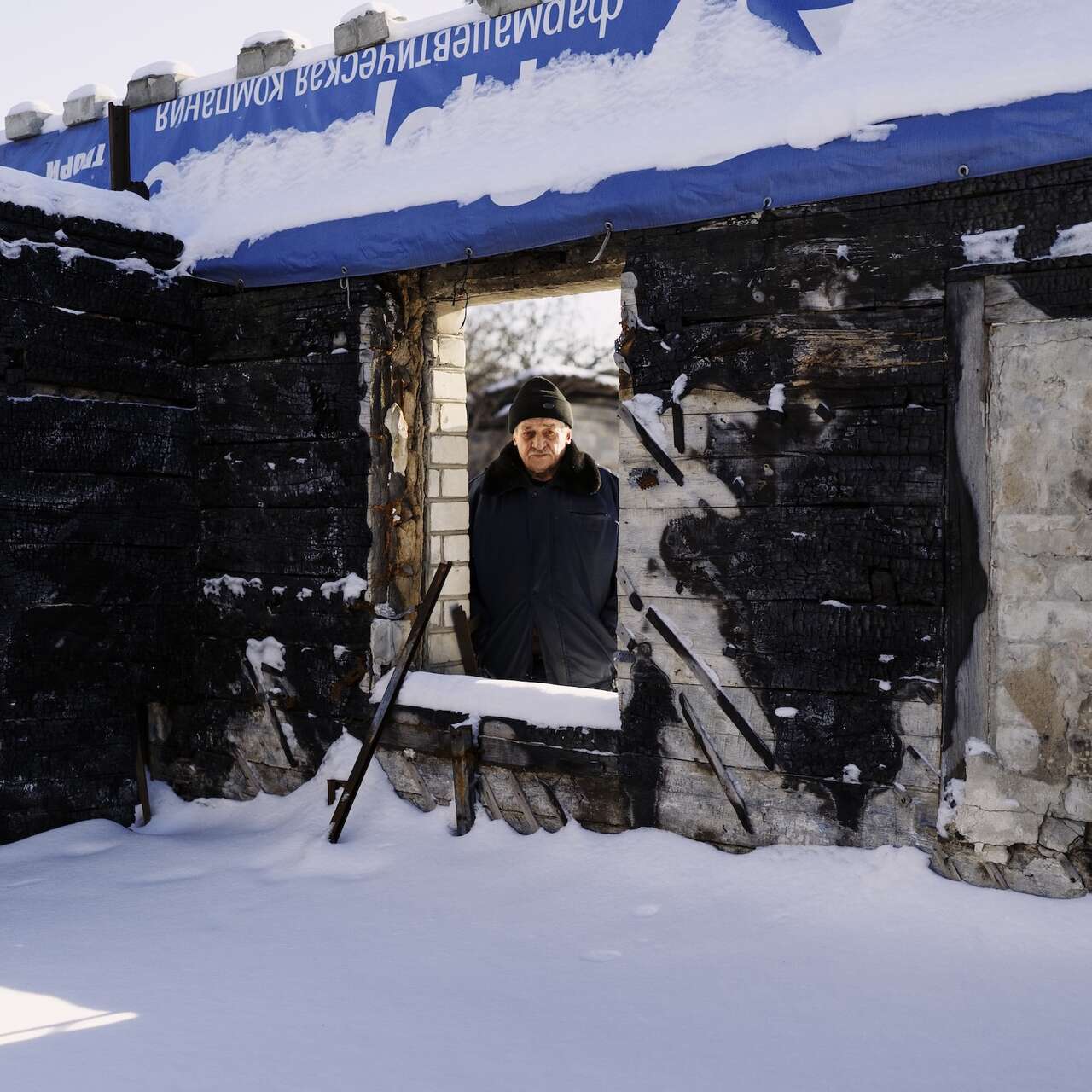 빅토르가 폭격으로 폐허가 된 집에서 카메라를 바라보고 있습니다.