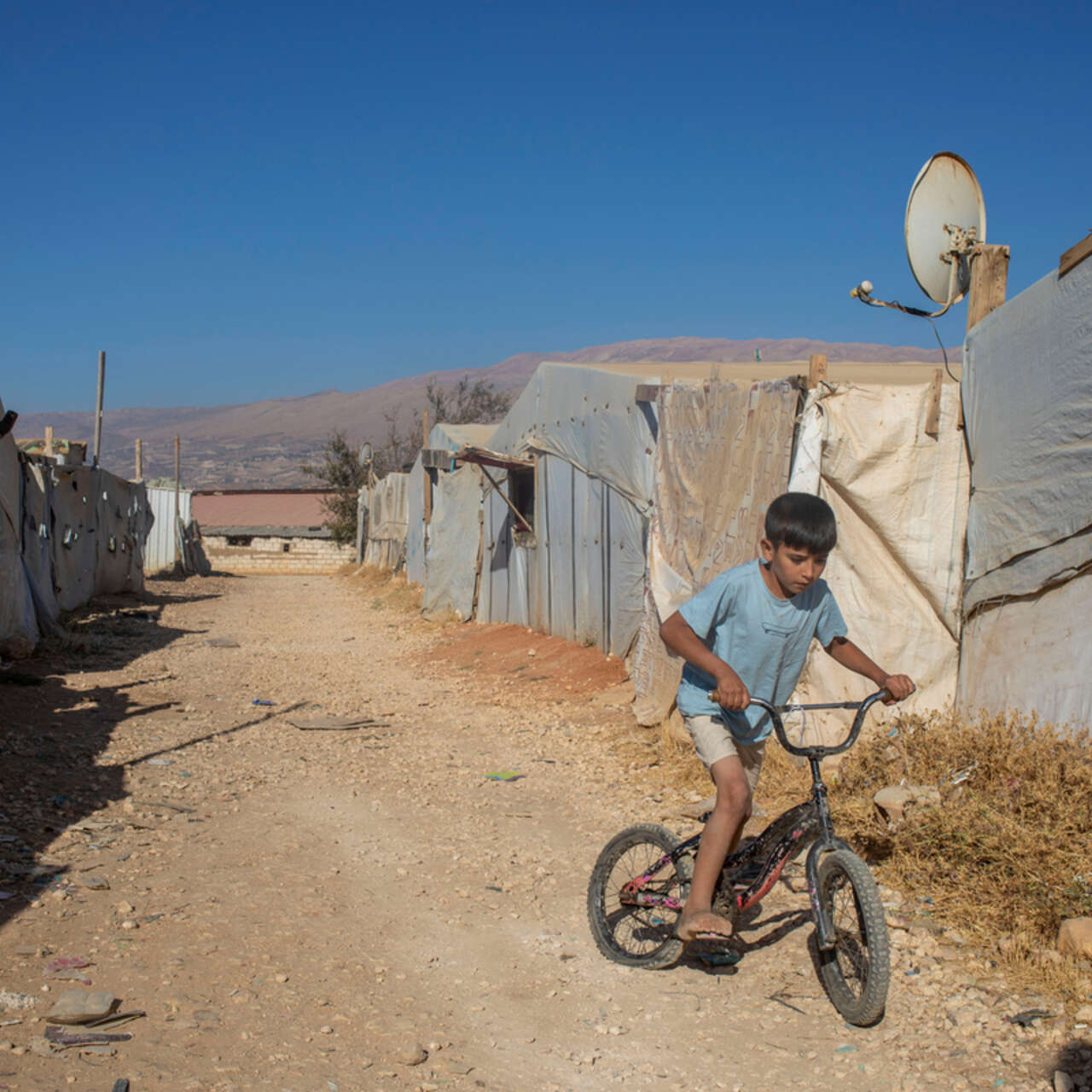 Ein Junge fährt Fahrrad in einem Lager für Geflüchtete in Libanon.