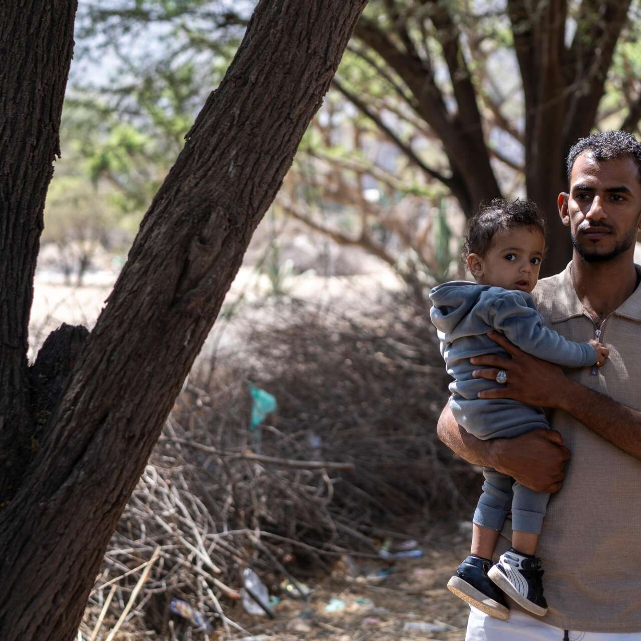 Nader carries his son Aws.