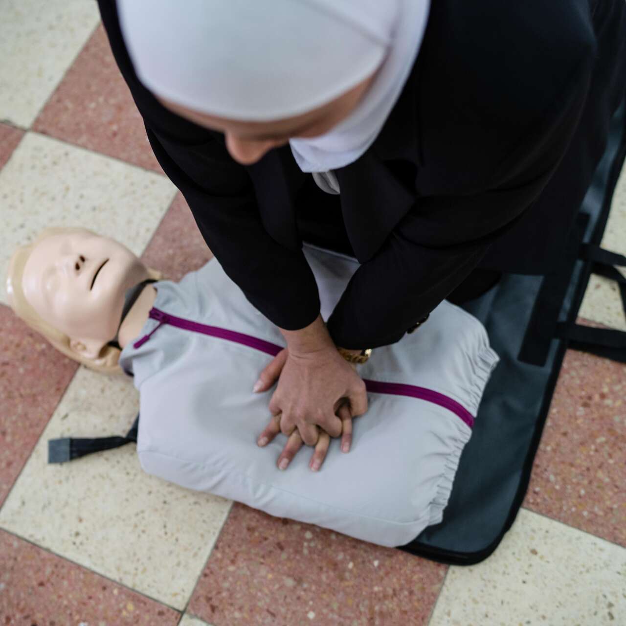 A first aid trainer teaches CPR techniques to attendees. 