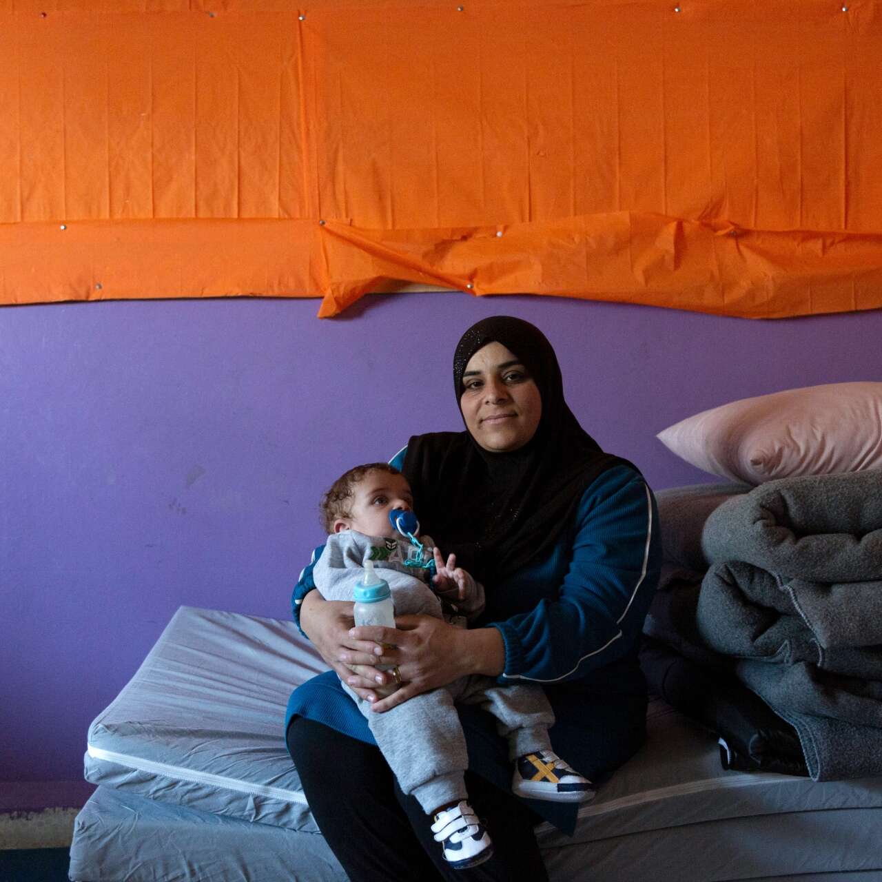 Warda poses for a photo while holding her young son, Mohammad.