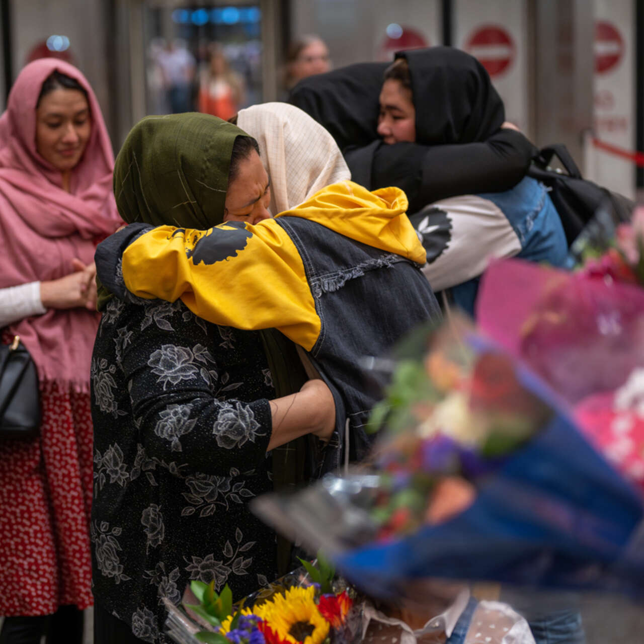 Två familjemedlemmar kramar om varandra på en flygplats