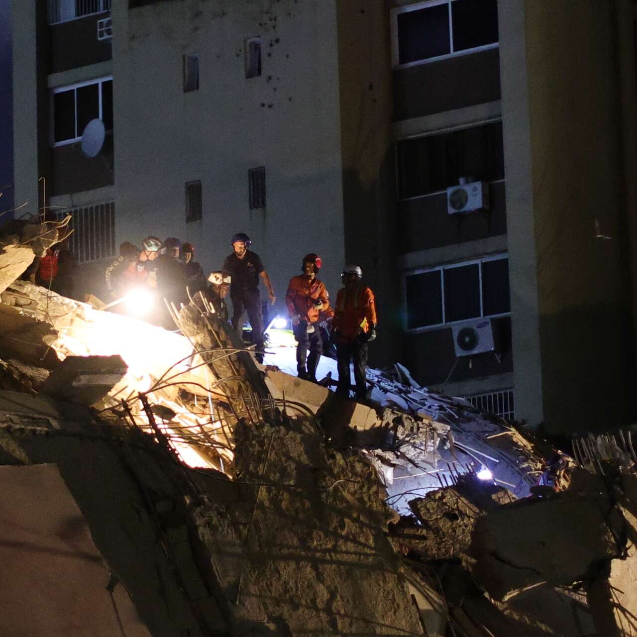 Rescuers search through the debris of a building destroyed by an earthquake in Venezuela.