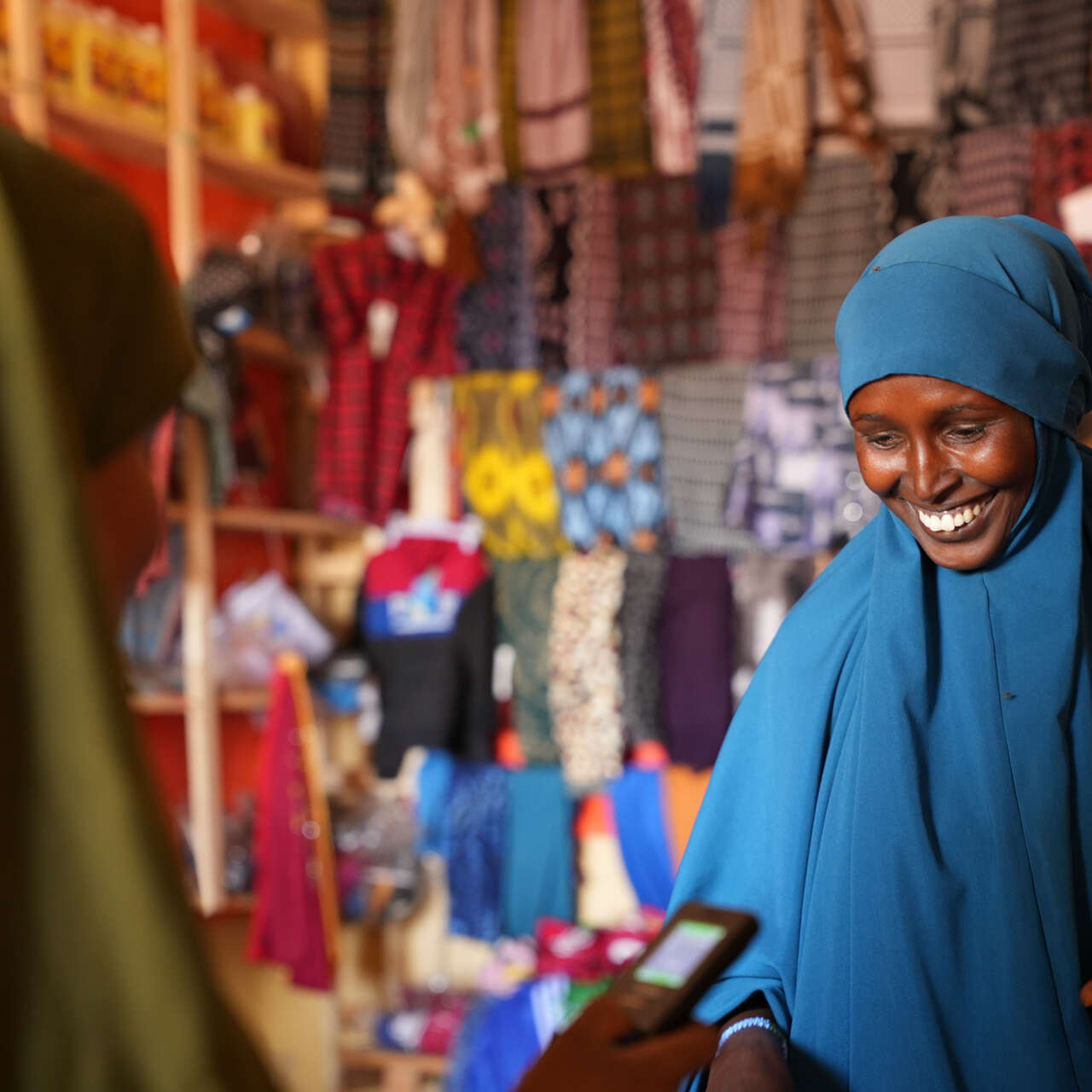 A woman buys fabric in a shop