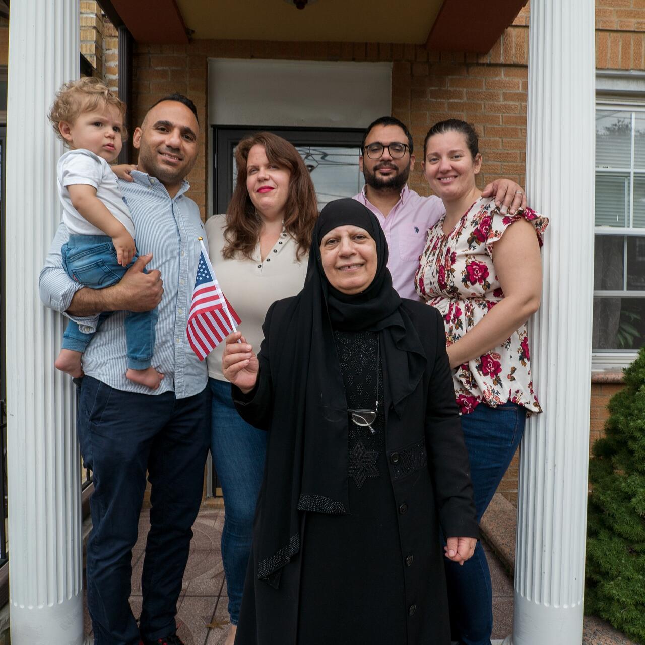 Maha al-Obaidi, 66, stands with her family outside their home in New York.