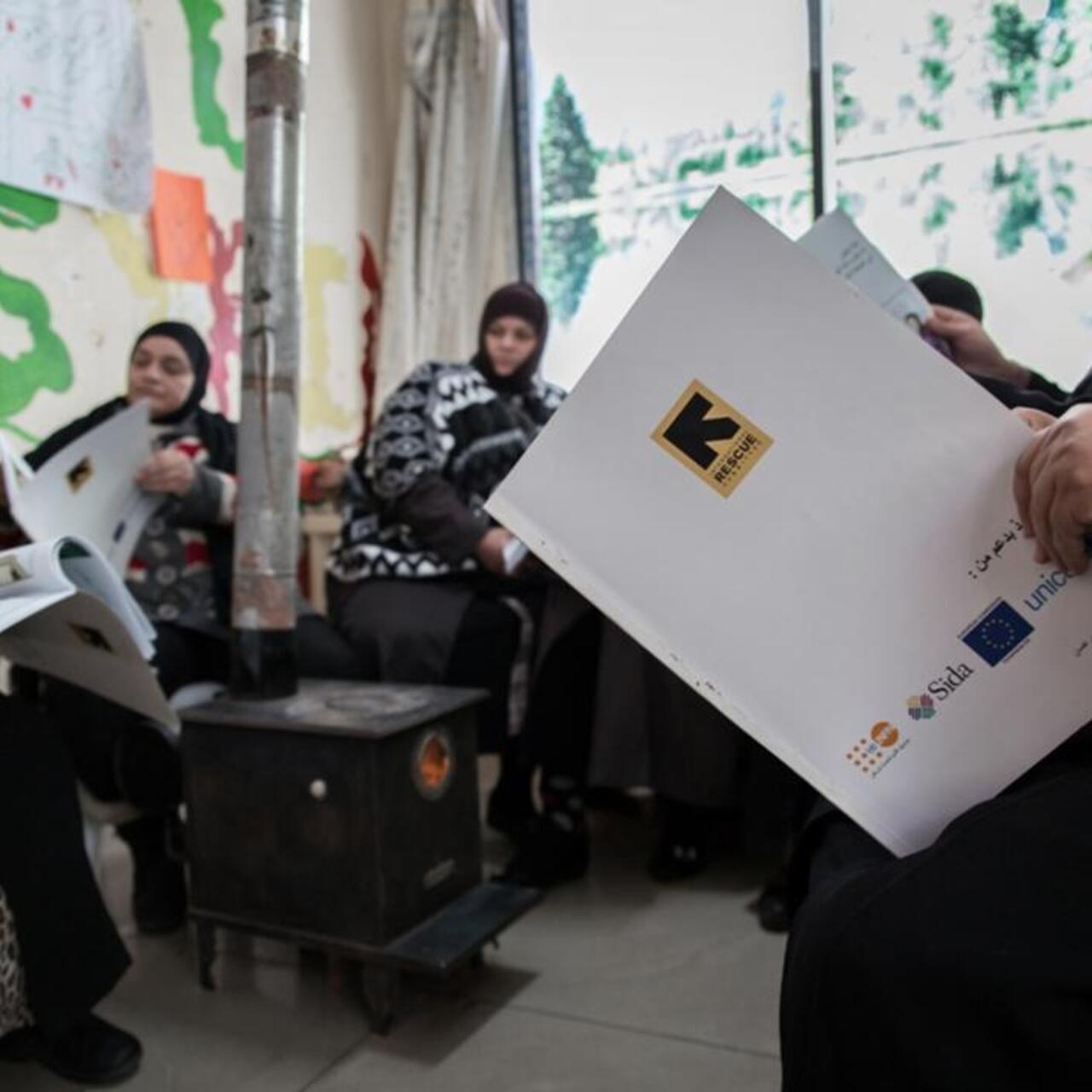 Women gather around a stove to take take part in a comic book activity