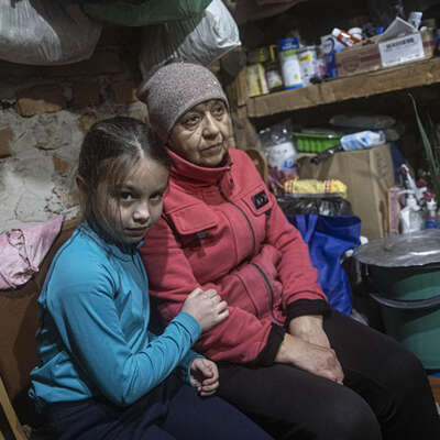 A young girl sits with a family member in a shelter in Lyman, Ukraine, after the Ukrainian army retook control.