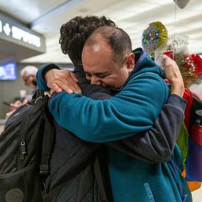 Two men embrace after a reunification at Dulles airport in Washington, DC